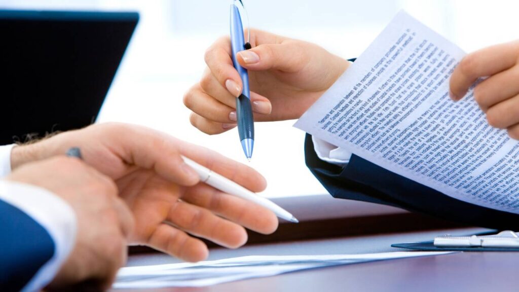 A woman and a man handling and signing important documents