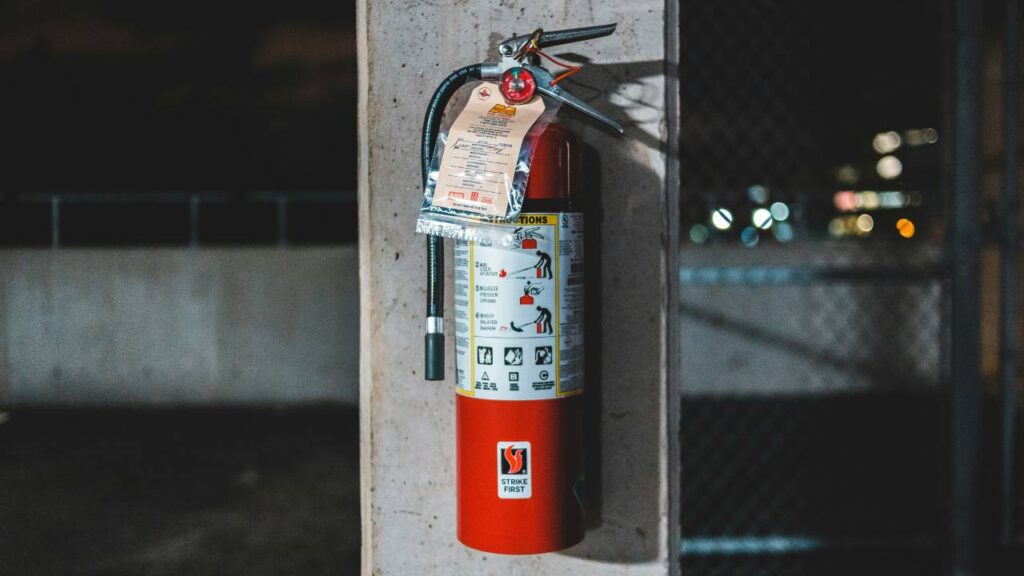 A fire extinguisher mounted on a concrete column