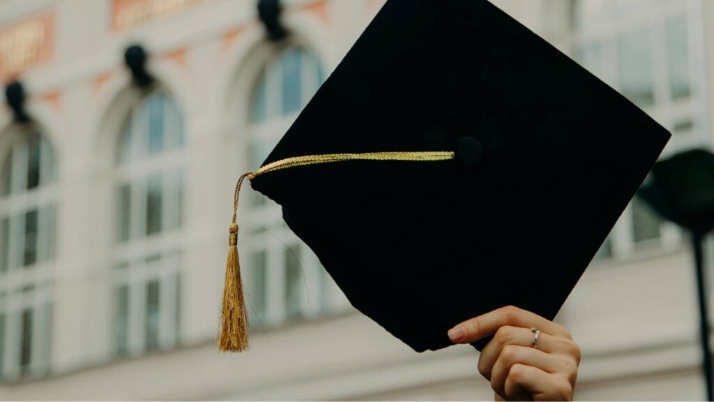 Person holding a graduation cap 